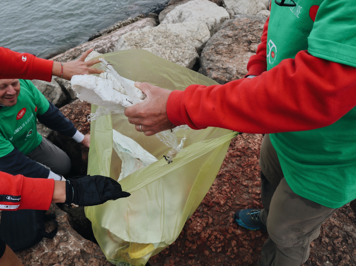 volunteers from carel industries at a beach clean-up of marine litter in chioggia