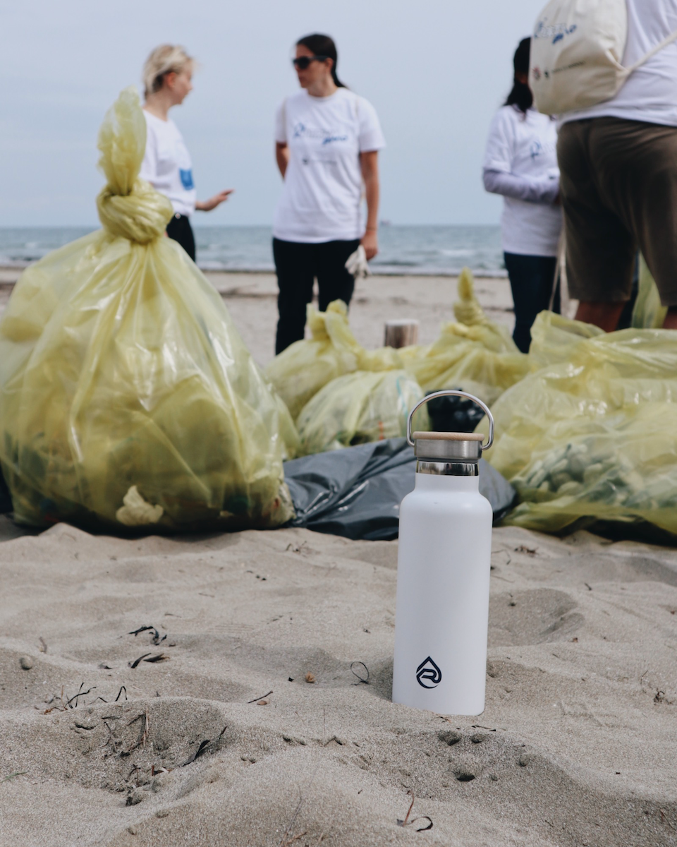 using a refill now water bottle during a beach clean-up in venice